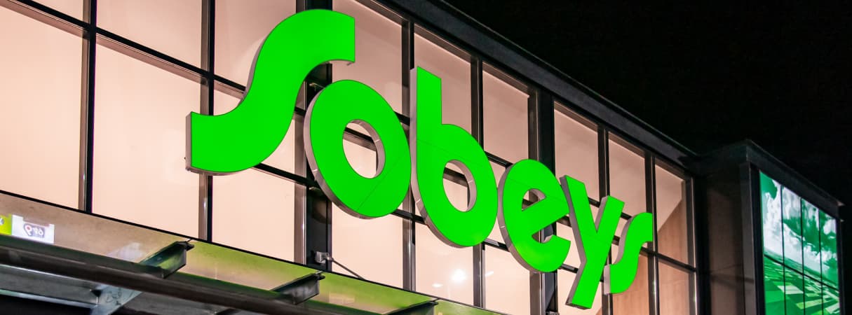 A lit Sobeys logo outside a building